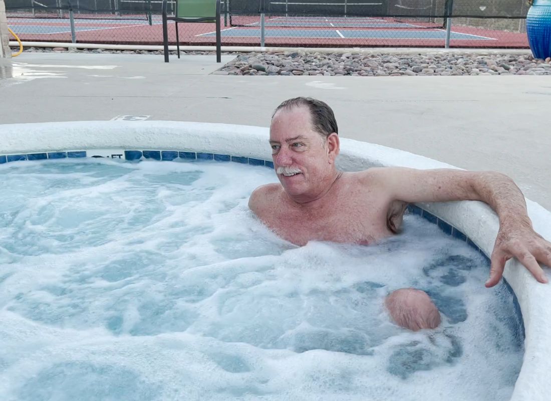 stariji čovek leži u bazenu u banji