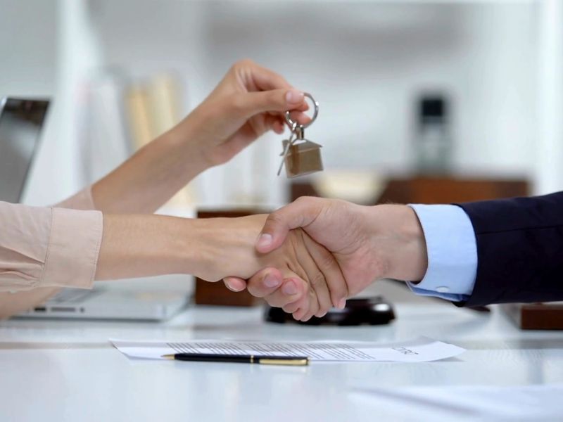 osobe se rukuju i predaju ključ kuće