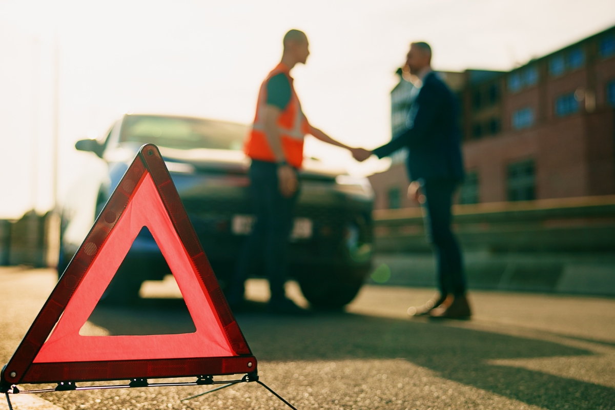 prikaz trougla na putu i osobe koja se rukuje sa majstorom za automobil