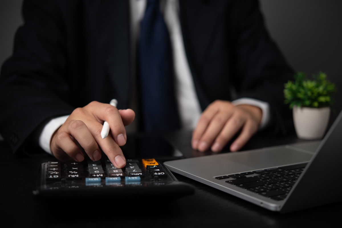 vlasnik firme računa nešto uz pomoć kalkulatora