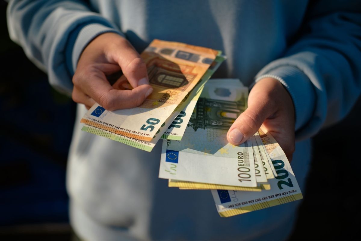 osoba drži mnogo novčanica u rukama